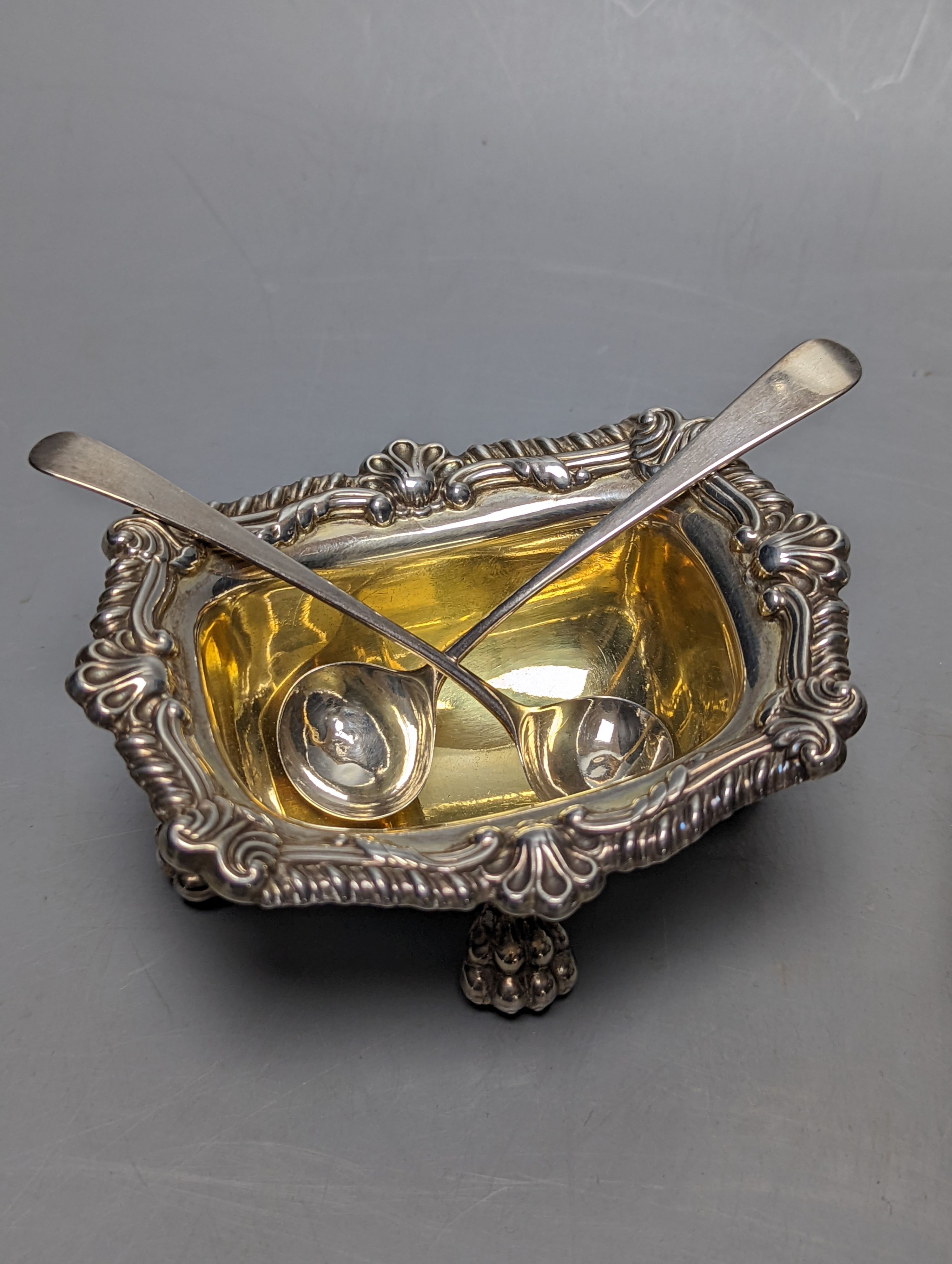 A pair of George III silver salts, with lion's paw feet, S.C.Younge & Co, Sheffield, 1817, 10.6cm, together with two pairs of associated George III silver condiment spoons